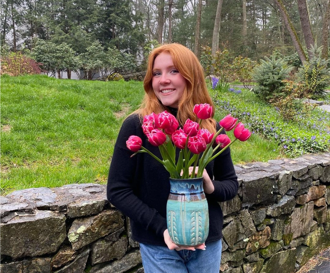 Catherine McGonagle, STEMS Co-Founder & President, holding a vase of pink tulips