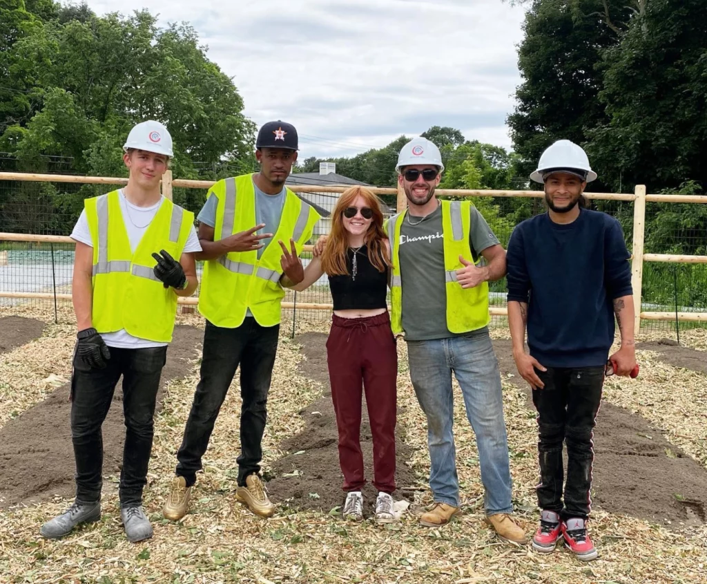Catherine McGonagle, STEMS Co-Founder & President, with workers in yellow vests at Lee's Farm in Wayland, MA